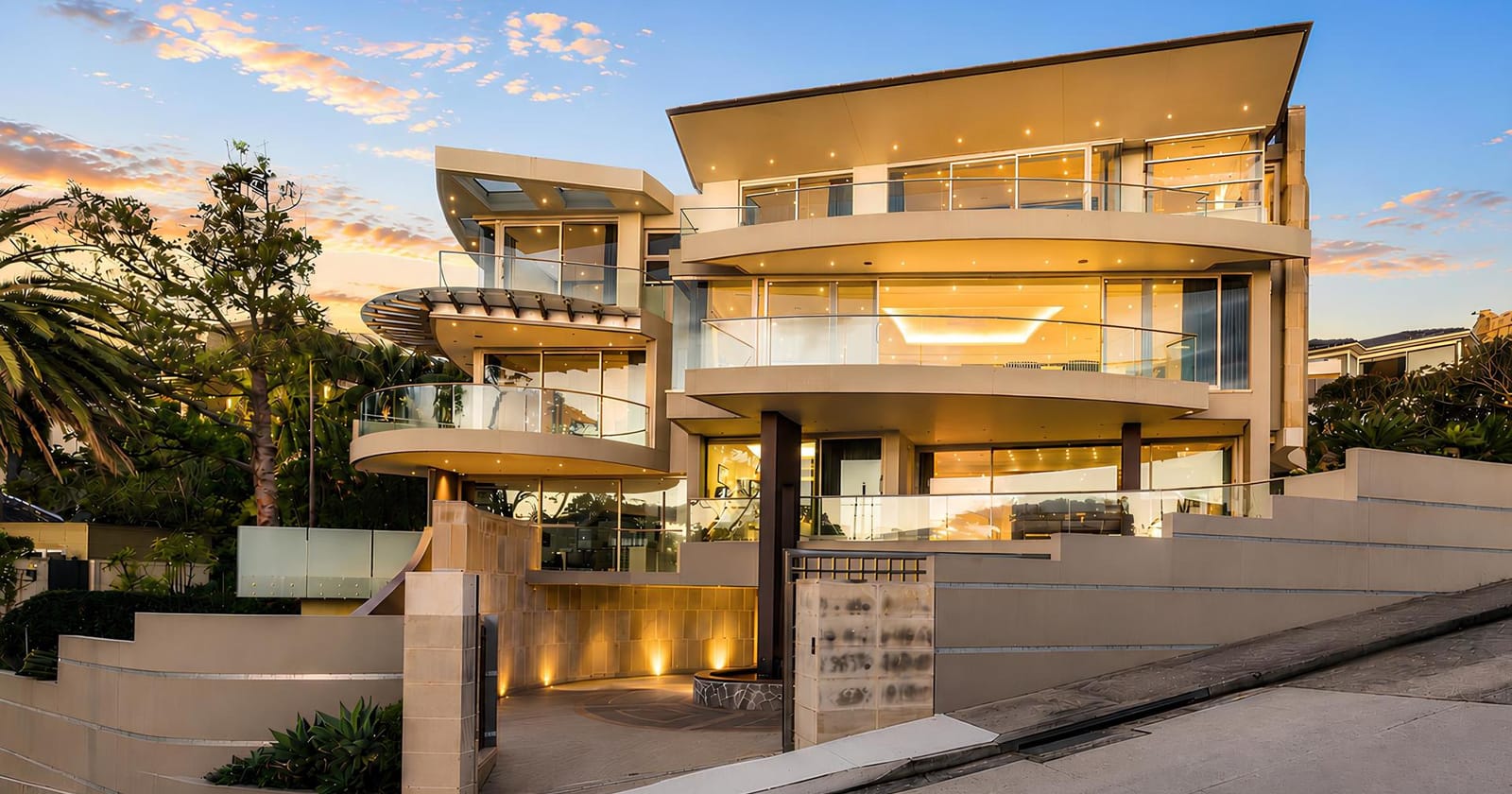 A terraced harbourside residence lit at dusk
